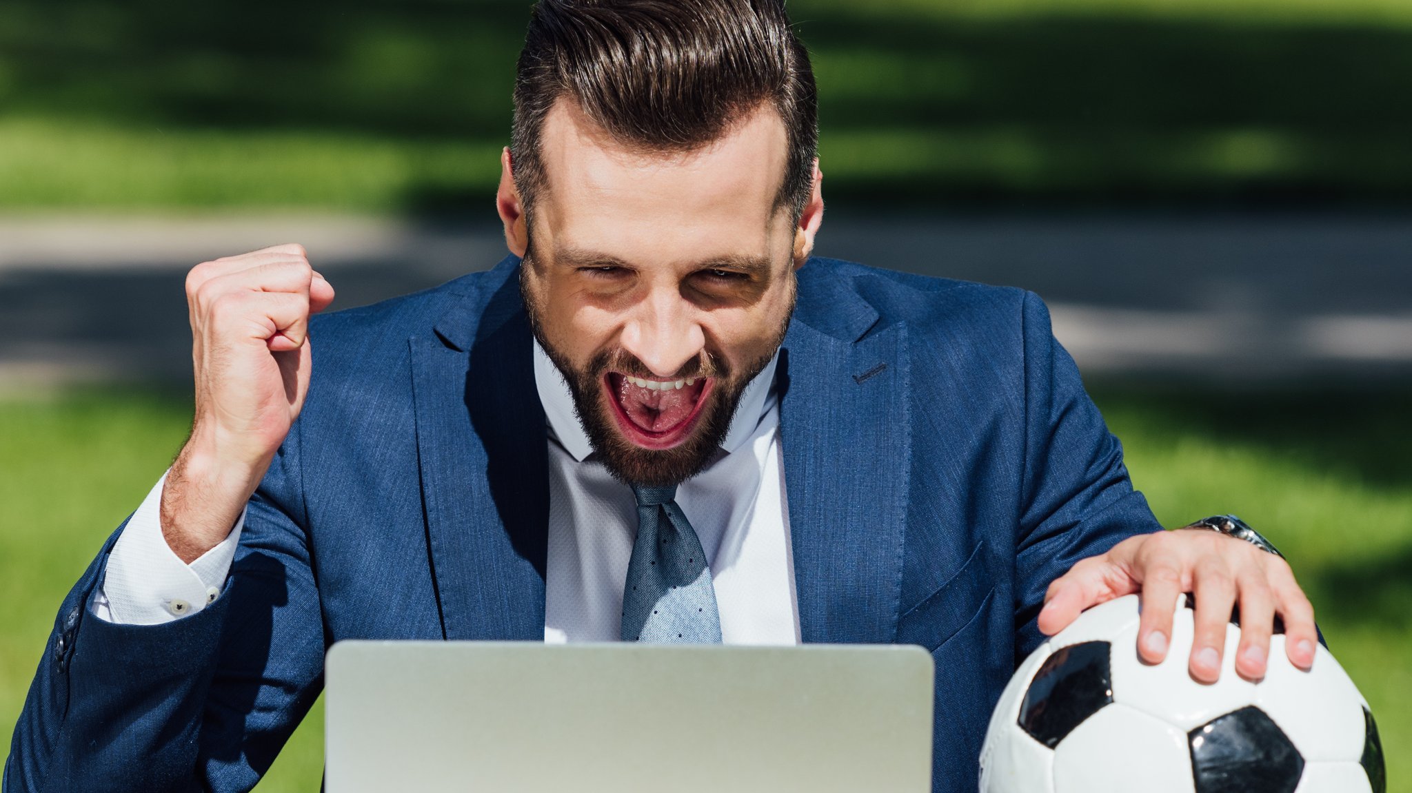 Ein Mann mit Fußball vor dem Laptop: Zahlreiche KI-Prognosen zur Fußball-Weltmeisterschaft sind im Umlauf. Aber wie gut ist die Künstliche Intelligenz, wenn's um die WM geht?