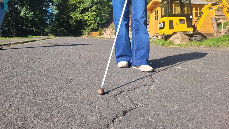 Eine Frau ertastet mit einem Blindenstock den Untergrund. | Bild: BR/Carlotta Sauer Eine Frau ertastet mit einem Blindenstock den Untergrund.