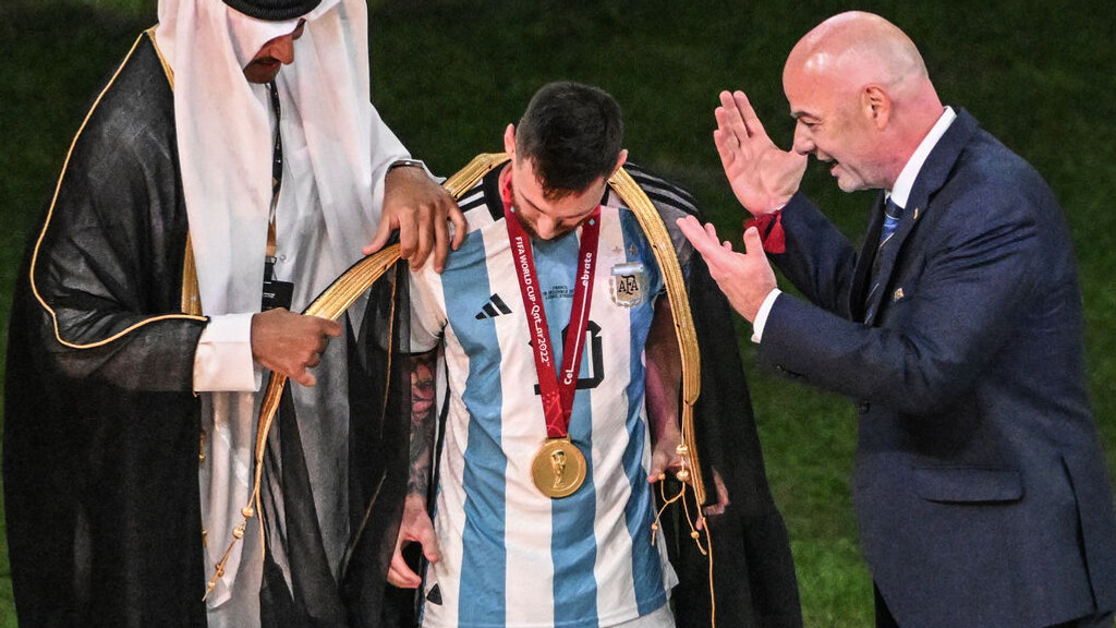 Ein Fußballer bekommt einen Mantel umgehängt