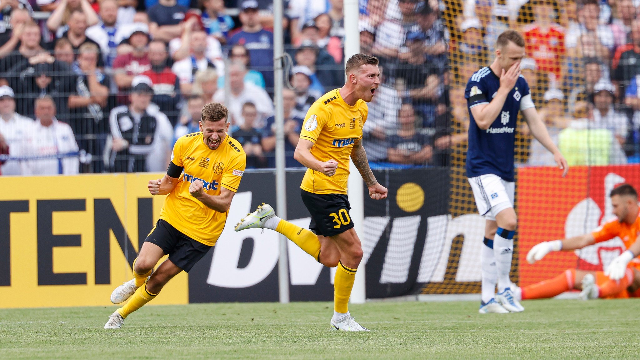 Die Bayreuther Alexander Nollenberger (l) und Nicholas Andermatt (M) bejubeln das 1:0. 