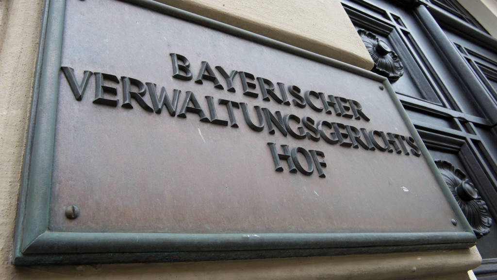 Ein Metallschild mit der Aufschrift "Bayerischer Verwaltungsgerichtshof" hängt im Mai 2014 an der Fassade des Gerichtsgebäudes in München.