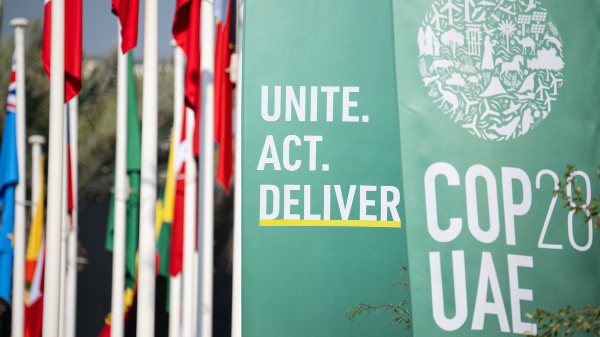 Schilder und Fahnen die auf die diesjährige Weltklimakonferenz der Vereinten Nationen in Dubai hinweisen.