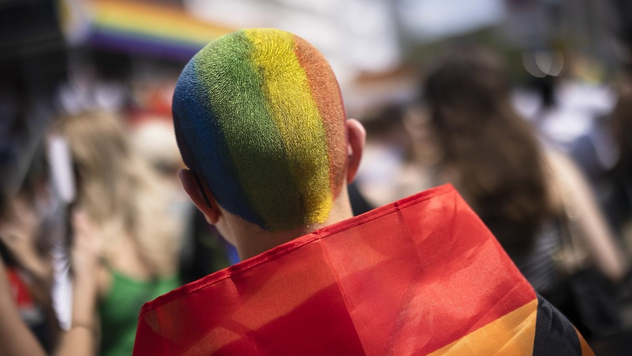 Mensch mit kurzen Haaren in Regenbogenfarben. 