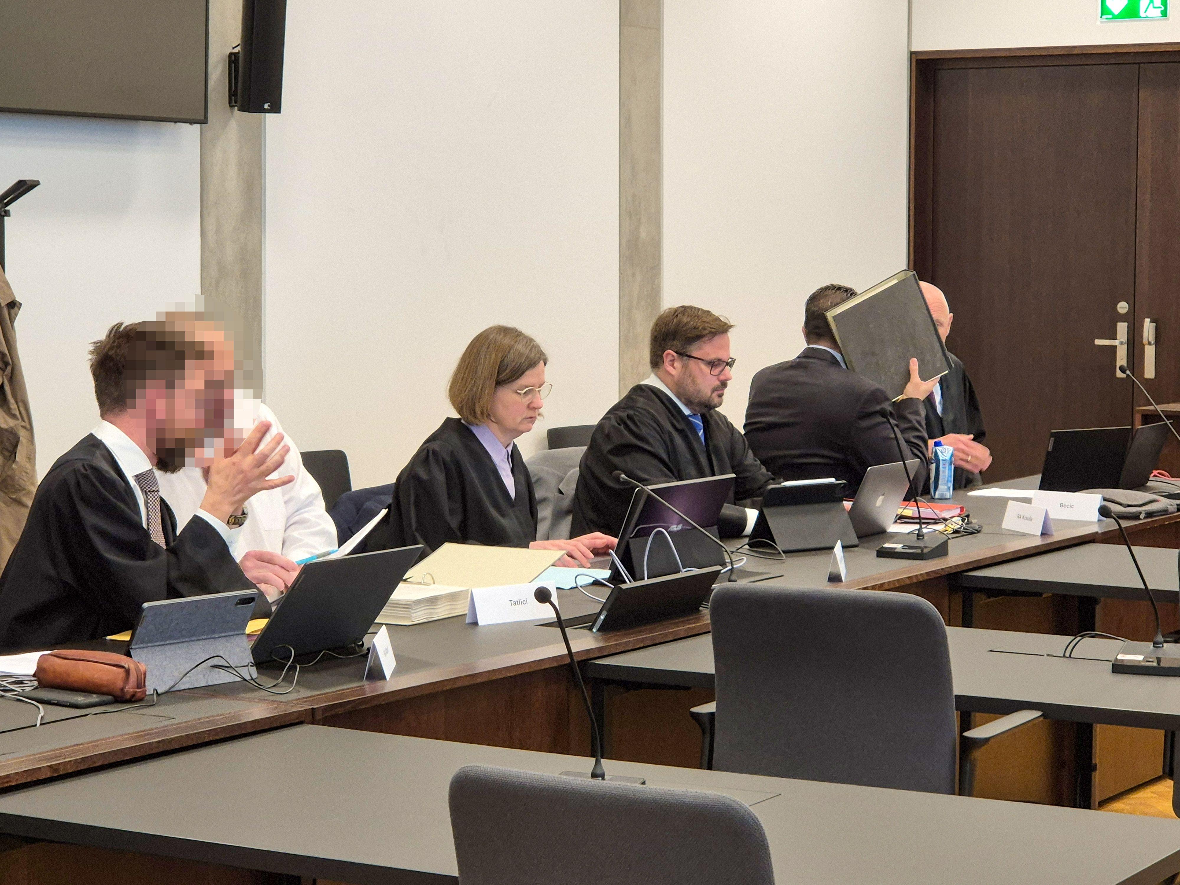 Angeklagte und deren Anwälte im Gerichtssaal