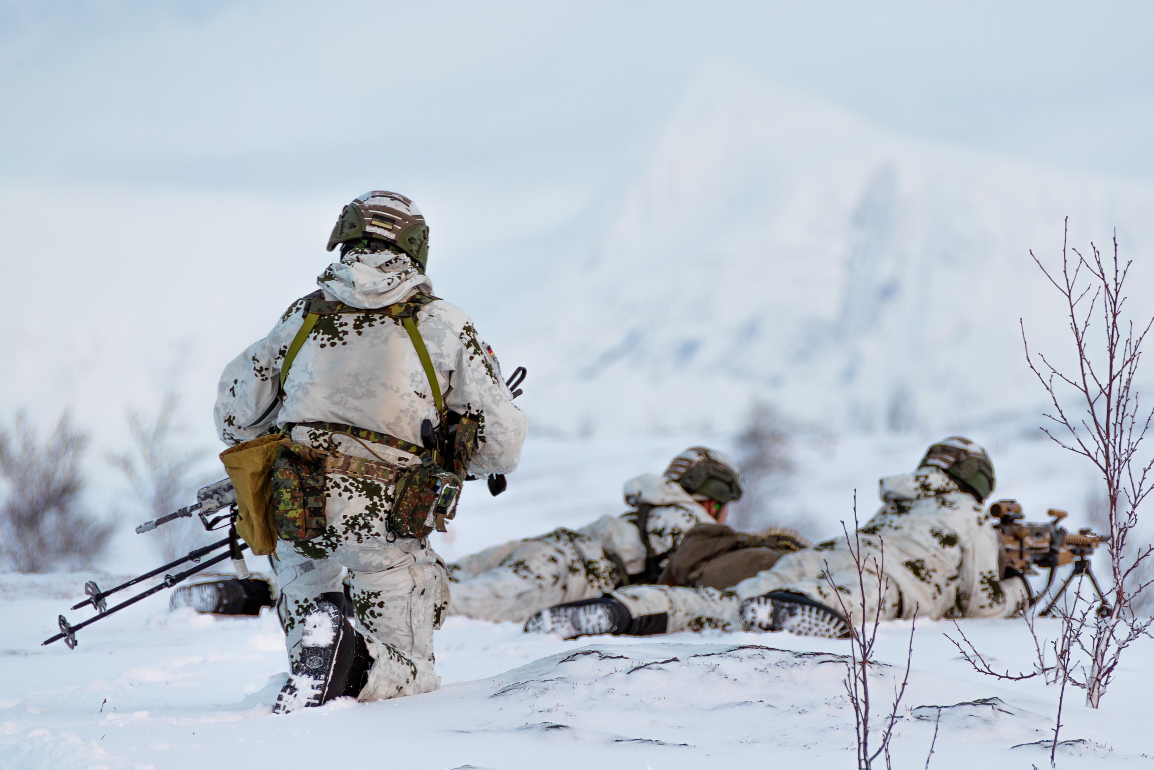 Gebirgsjäger der Bundeswehr sind mit einem Maschinengewehr in der kargen Landschaft Nord-Norwegens in Stellung gegangen. Sie nehmen an einem Großmanöver teil. 