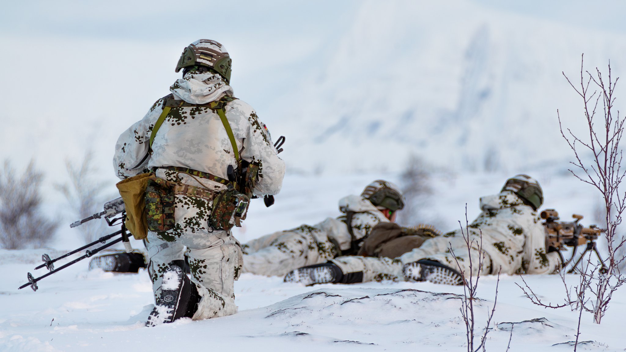 Gebirgsjäger der Bundeswehr sind mit einem Maschinengewehr in der kargen Landschaft Nord-Norwegens in Stellung gegangen. Sie nehmen an einem Großmanöver teil. 
