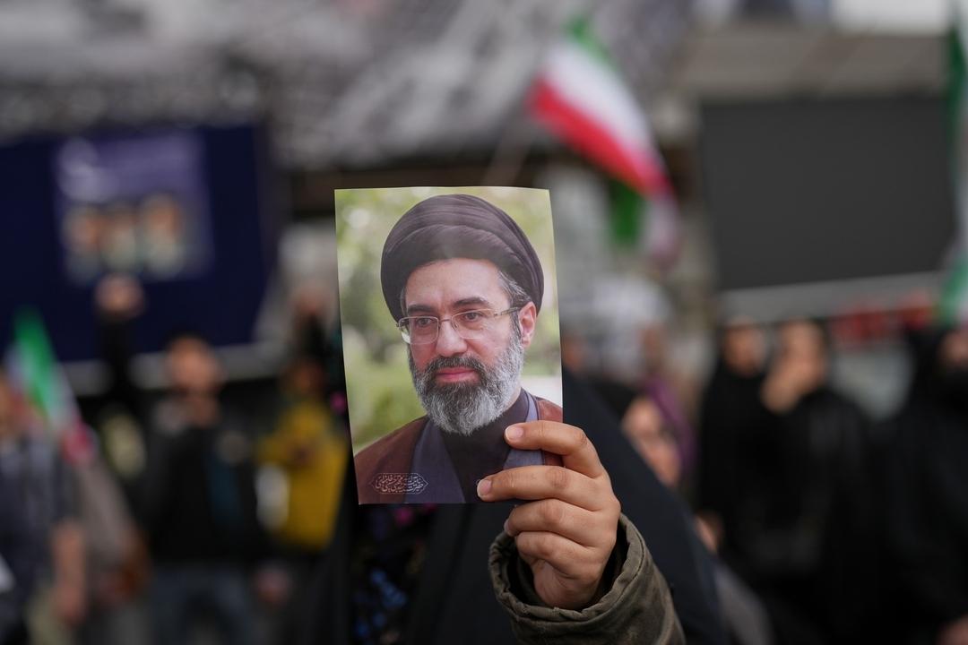 08.04.2026, Iran, Teheran: Ein Demonstrant hält ein Bild von Modschtaba Chamenei, Irans neuem Religionsführer und Staatsoberhaupt, während einer Versammlung nach der Ankündigung einer zweiwöchigen Waffenruhe mit den Vereinigten Staaten und Israel. 