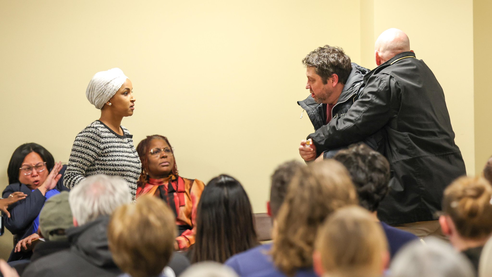 Ein Mann spritzt der Abgeordneten Omar während einer Townhall-Veranstaltung mit einer Spritze eine Substanz ins Gesicht.