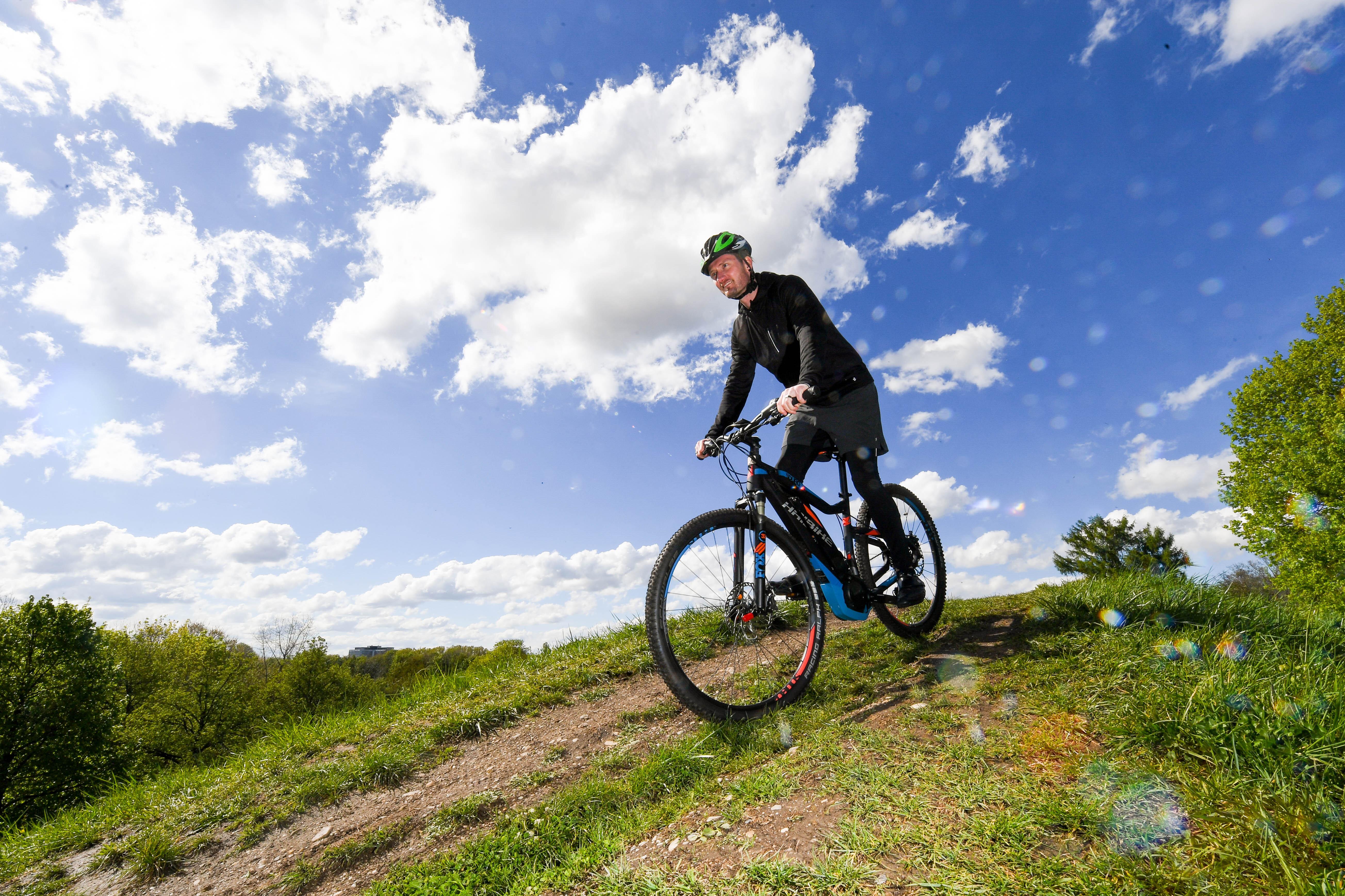 Mann mit Helm auf einem Pedelec in der bayerischen Natur.