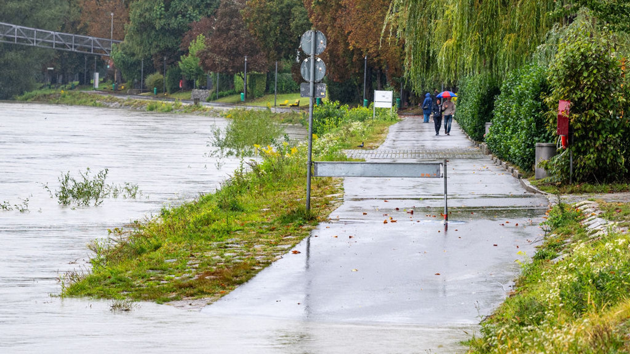 Passau: Eine Absperrung steht am überschwemmten Innufer.