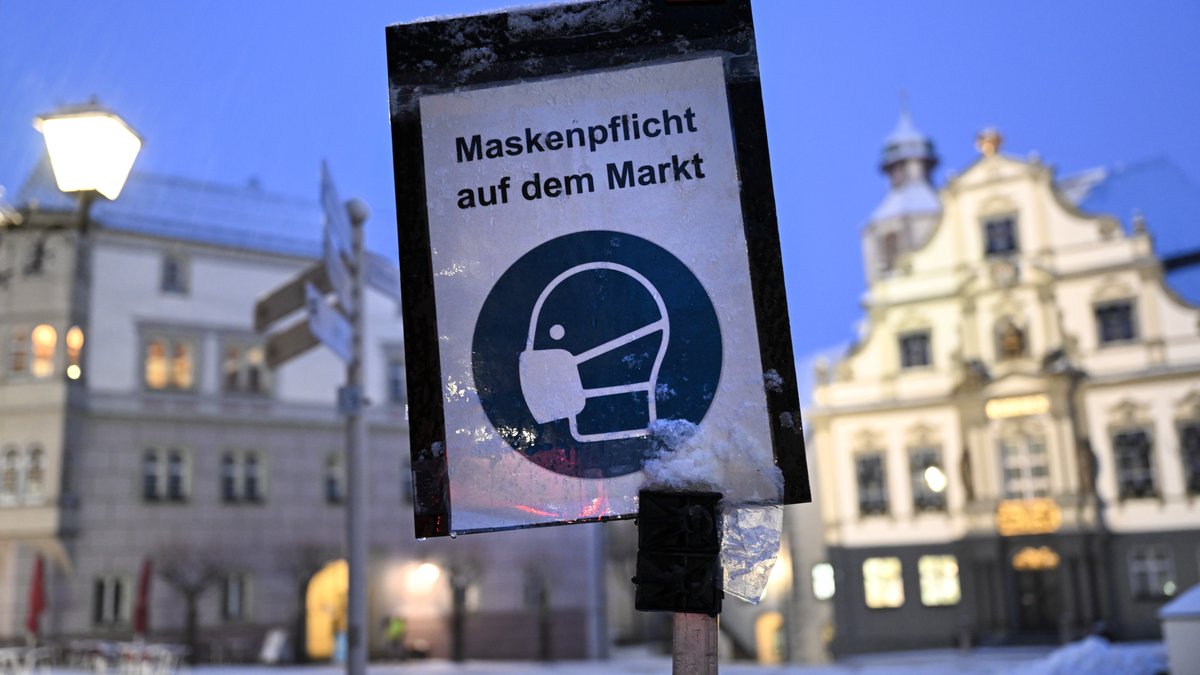 Ein Schild weist in der Innenstadt Wangen im Allgäu auf die Maskenpflicht auf dem Markt hin.