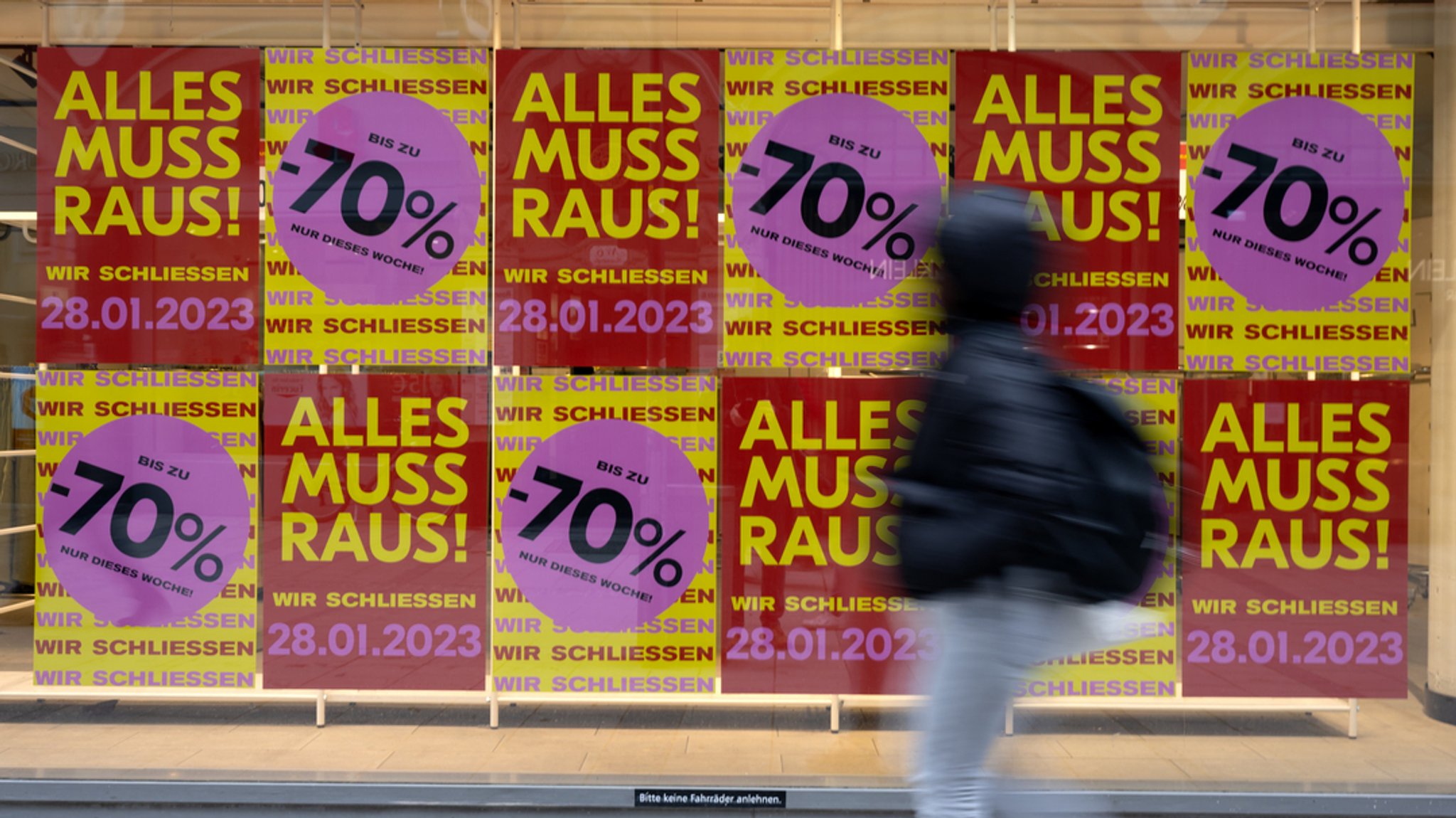 Mehrere "Alles muss raus"-Plakate hängen an einer Wand