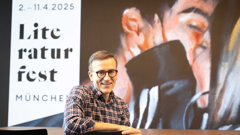 Der Berliner Schriftsteller Daniel Schreiber vor dem Plakat des Literaturfests München 2025 | Bild: Catherina Hess Der Berliner Schriftsteller Daniel Schreiber vor dem Plakat des Literaturfests München 2025