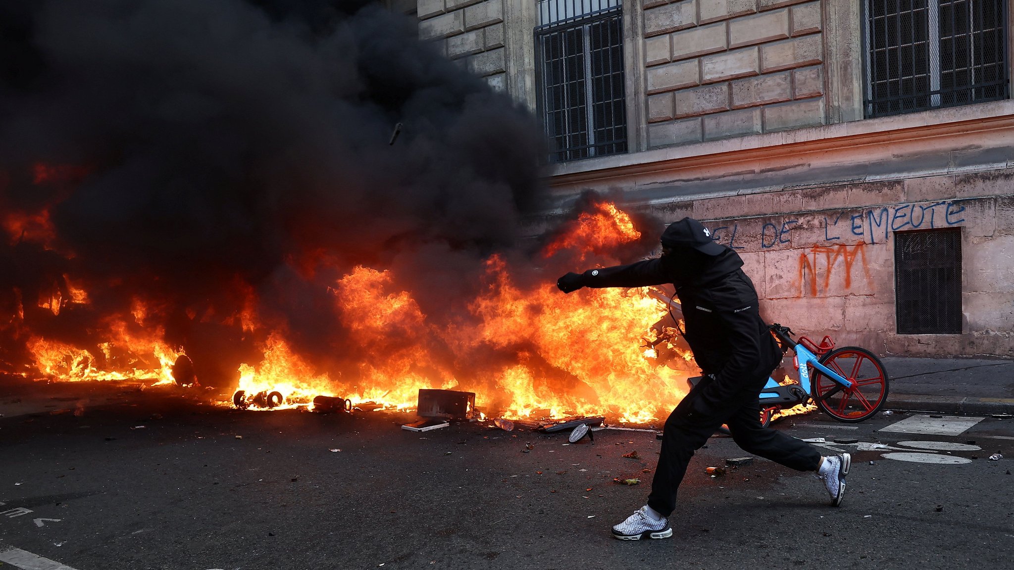 Demonstrant vor ausgebranntem Auto | Bild: Reuters/Abdul Saboor Demonstrant vor ausgebranntem Auto