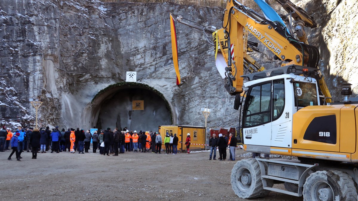Arbeiter und Gäste stehen nach dem offiziellen Tunnelanschlag vor dem zukünftigen Nordportal des Kramertunnels. (Archivbild)