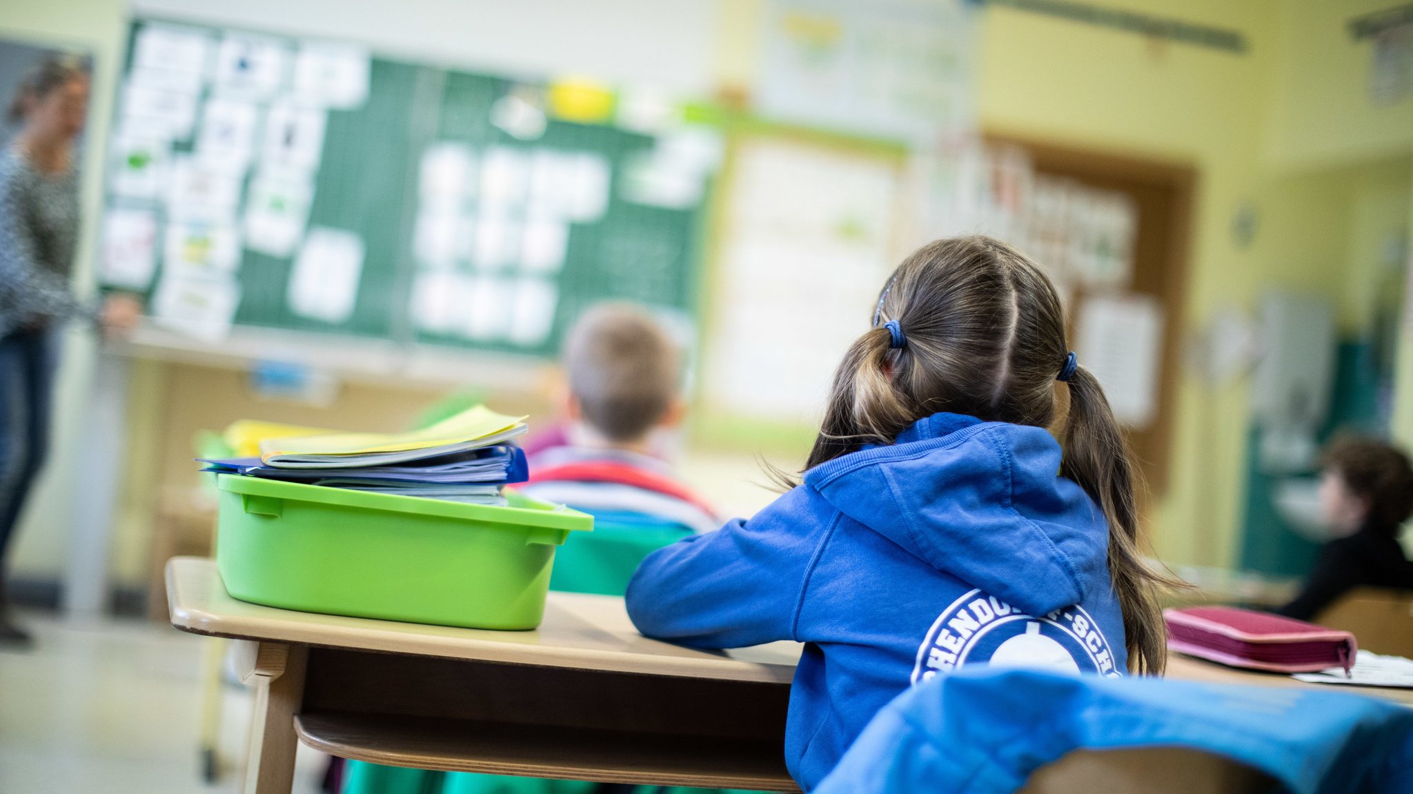 Schülerinnen und Schüler einer Grundschule sitzen mit Abstand in ihrem Klassenraum.