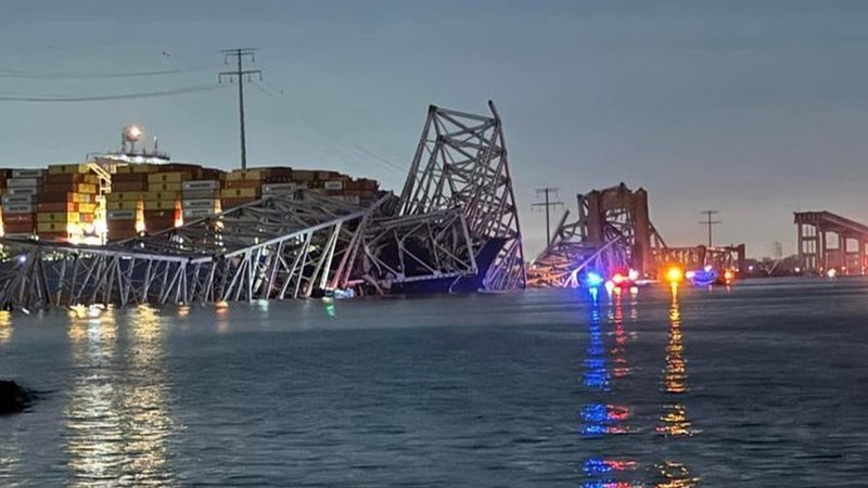 Das Frachtschiff, das die Brücke gerammt hat, und deren Trümmer im Wasser.