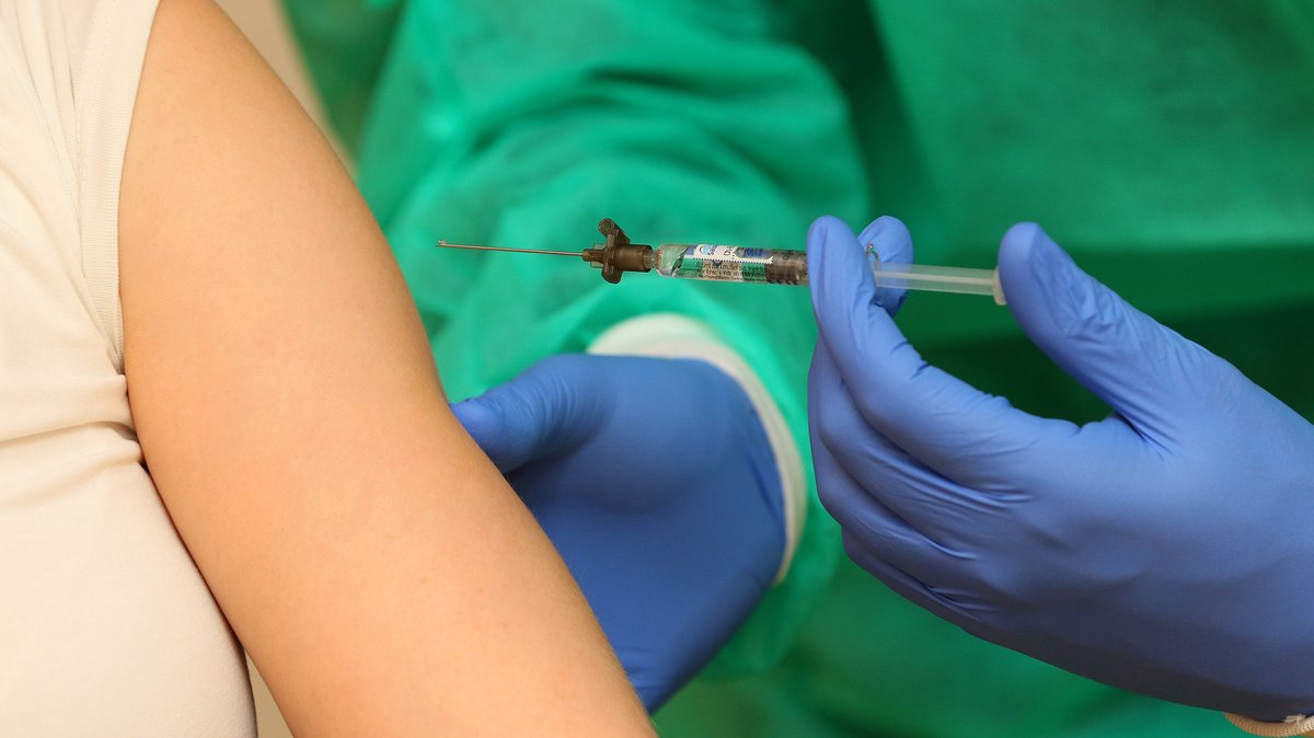 Medizinische Fachperson verabreicht eine Impfung