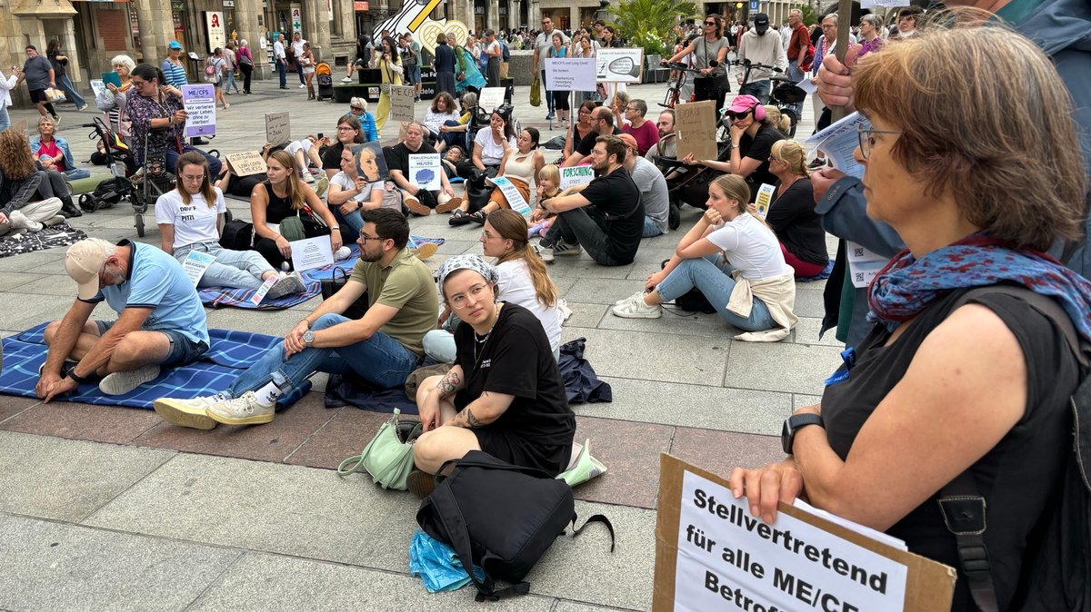 Demonstration am Münchner Marienplatz: Viele Menschen sitzen mit Schildern auf dem Boden.