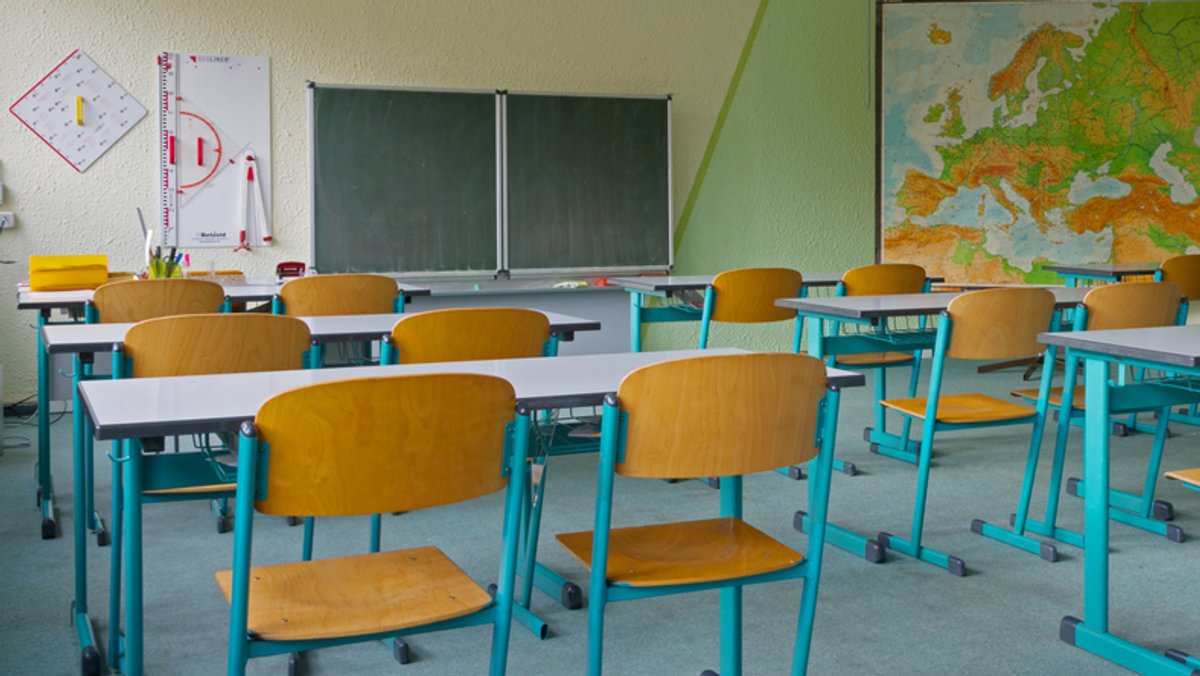 Tische und Stühle in einem leeren Klassenzimmer