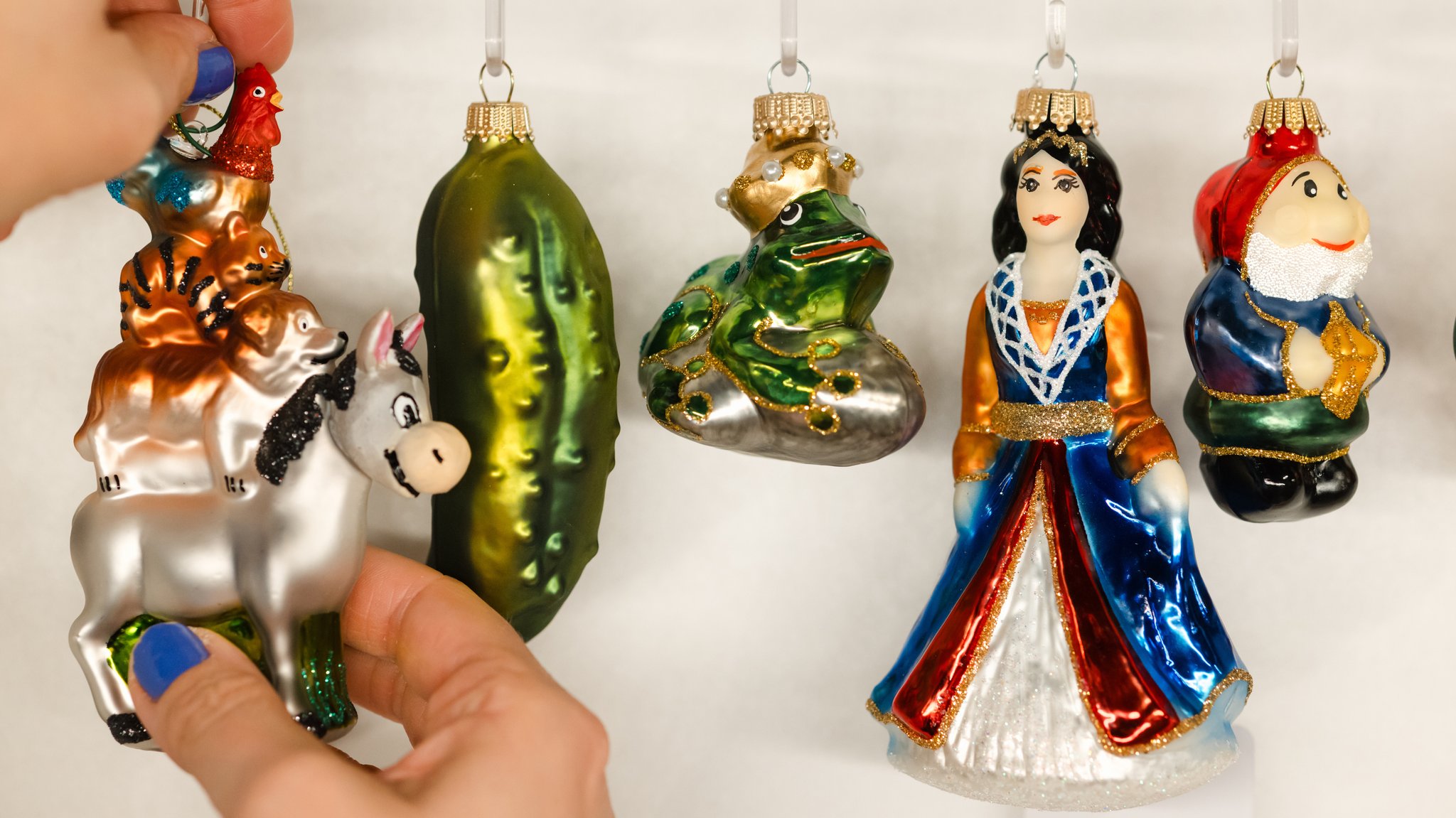 Eine Frau zeigt Märchenfiguren als Christbaumschmuck aus Lauscha.