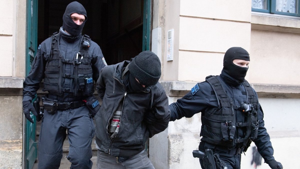 Dresden: Polizisten führen bei einer Razzia im Stadtteil Pieschen einen Tatverdächtigen aus einem Hauseingang.