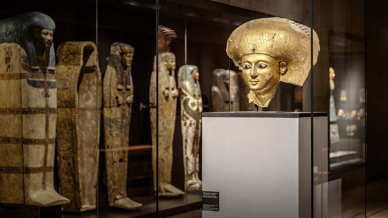Blick in den Ausstellungsraum des SMÄK München mit Mumiensärgen und einer Büste | Bild: SMÄK, Foto: Claus Rammel Blick in den Ausstellungsraum des SMÄK München mit Mumiensärgen und einer Büste