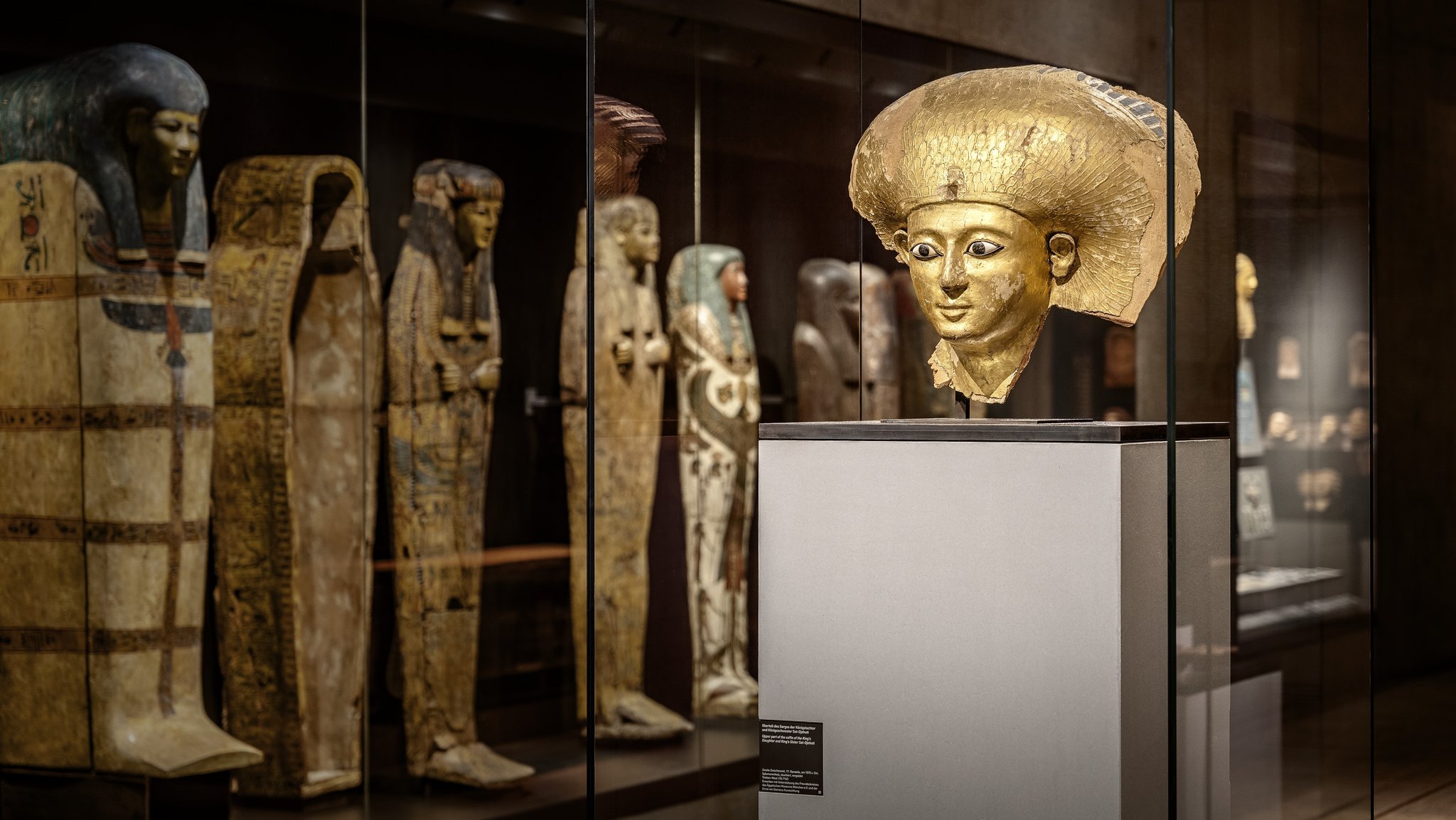 Blick in den Ausstellungsraum des SMÄK München mit Mumiensärgen und einer Büste