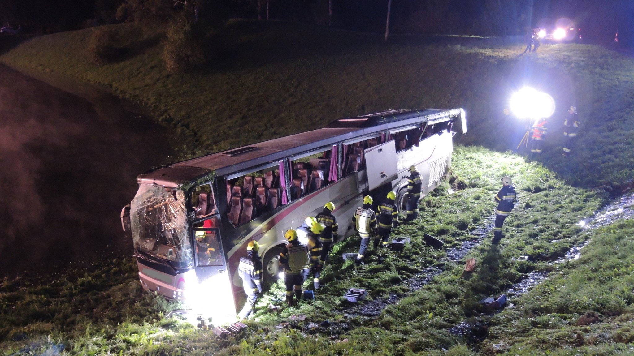 Österreich, Bad Mitterndorf: Feuerwehr und Rettungshelfer neben dem Reisebus, der am Donnerstagabend im steirischen Salzkammergut bei Bad Mitterndorf einen Hang hinabgestürzt ist und sich überschlagen hat. Nach dem Unfall wurden vier Schwer- und 20 Leichtverletzte in Krankenhäusern versorgt