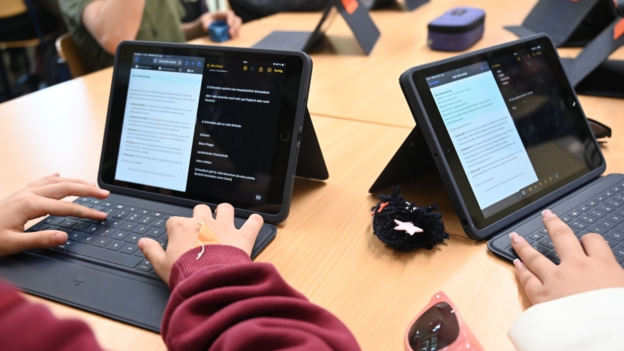 Zwei Mädchen arbeiten in der Schule mit dem KI-Chatbot "Telli“.