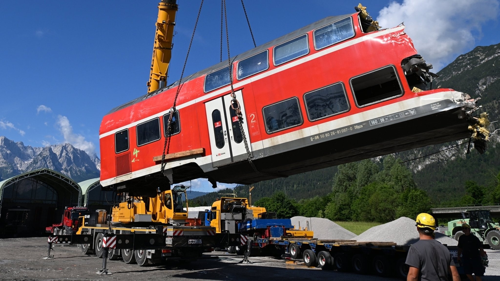 Ein Waggon wird mit einem Kran von den Gleisen gehoben