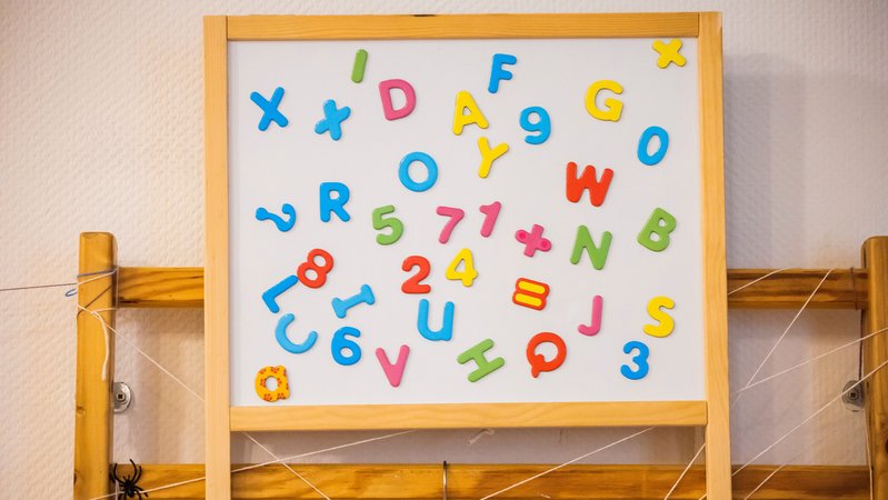Eine Tafel mit bunten magnetischen Buchstaben und Zahlen in einer Kita. | Bild: picture alliance/dpa | Christoph Soeder Eine Tafel mit bunten magnetischen Buchstaben und Zahlen in einer Kita.