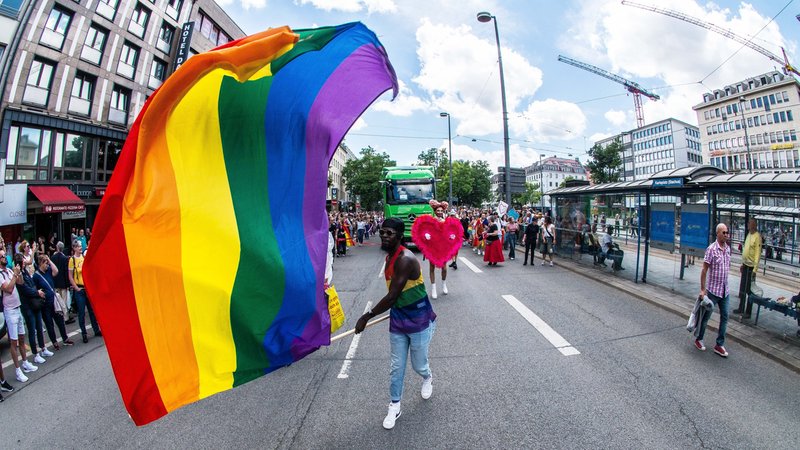 CSD-PolitParade 2024 in München, ein Mann auf der Straße in der Nähe des Stachus schwenkt eine riesige Regenbogenfahne. | Bild: picture alliance / ZUMAPRESS.com | Sachelle Babbar CSD-PolitParade 2024 in München, ein Mann auf der Straße in der Nähe des Stachus schwenkt eine riesige Regenbogenfahne.