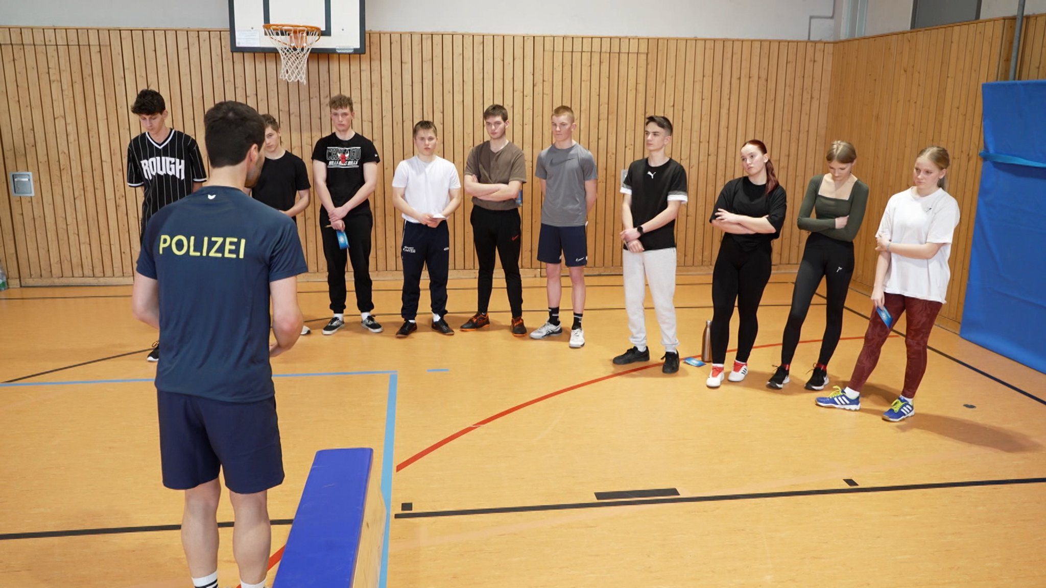 Ein Polizist mit einer Gruppe Schülern während eines Sporttests.