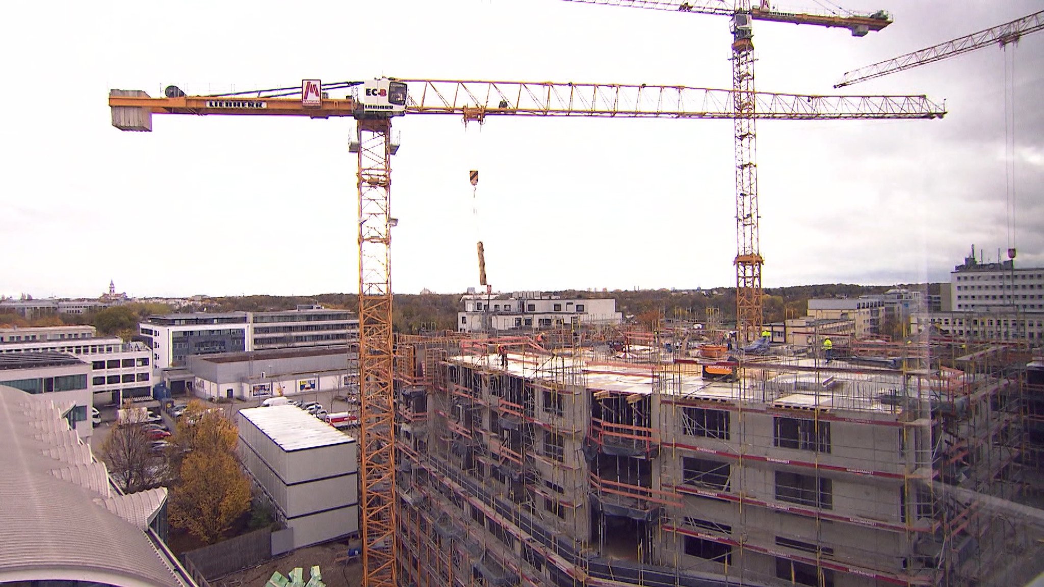 Baukräne stehen auf einer Wohnungsbaustelle in Bayern.