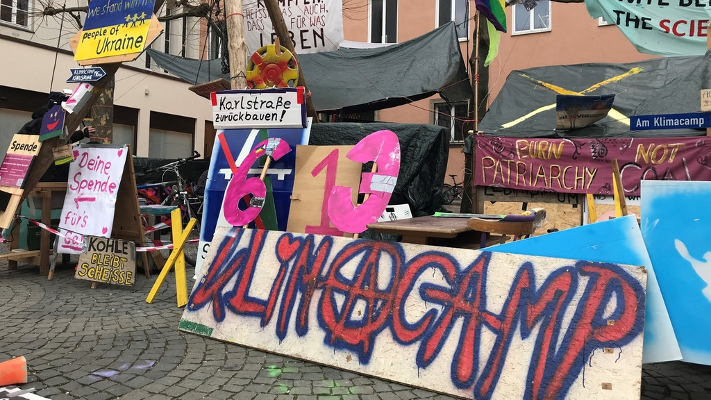 Das Augsburger Klimacamp: Viele Transparente und ein Bretterverschlag mit Plastikfolie als Dach