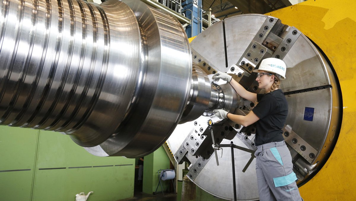 Eine Siemens-Beschäftigte arbeitet an einer großen Maschine (Symbolbild).