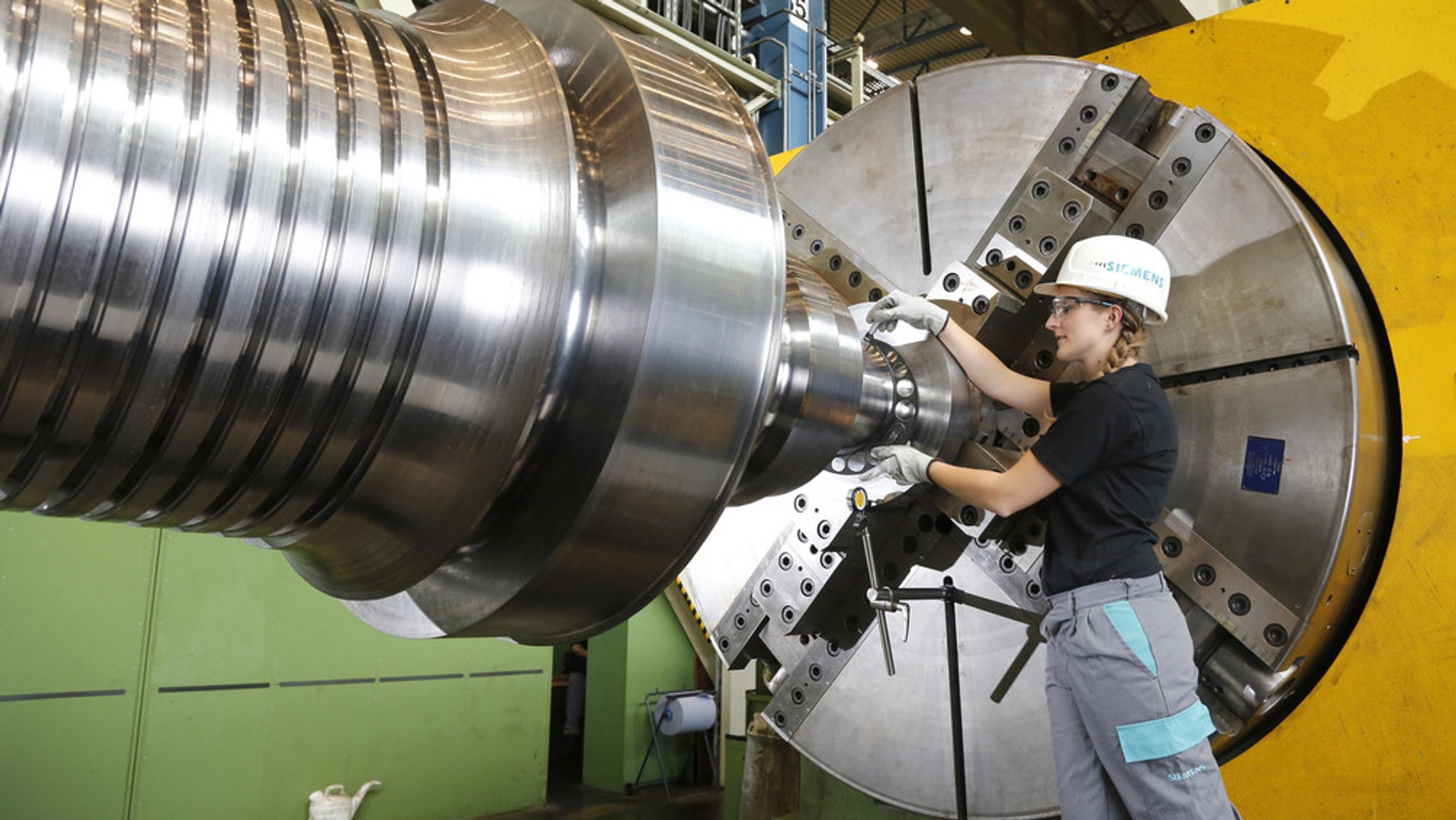 Eine Siemens-Beschäftigte arbeitet an einer großen Maschine (Symbolbild).