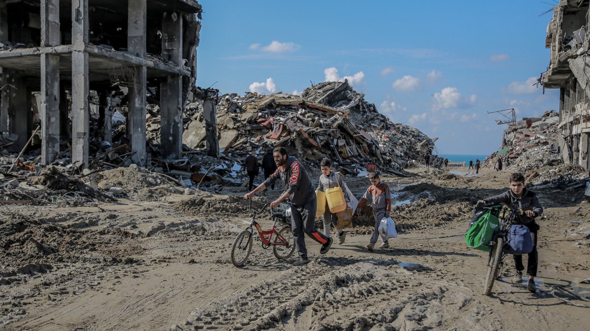 Palästinenser gehen an den Trümmern der Al-Maqousi-Türme vorbei.