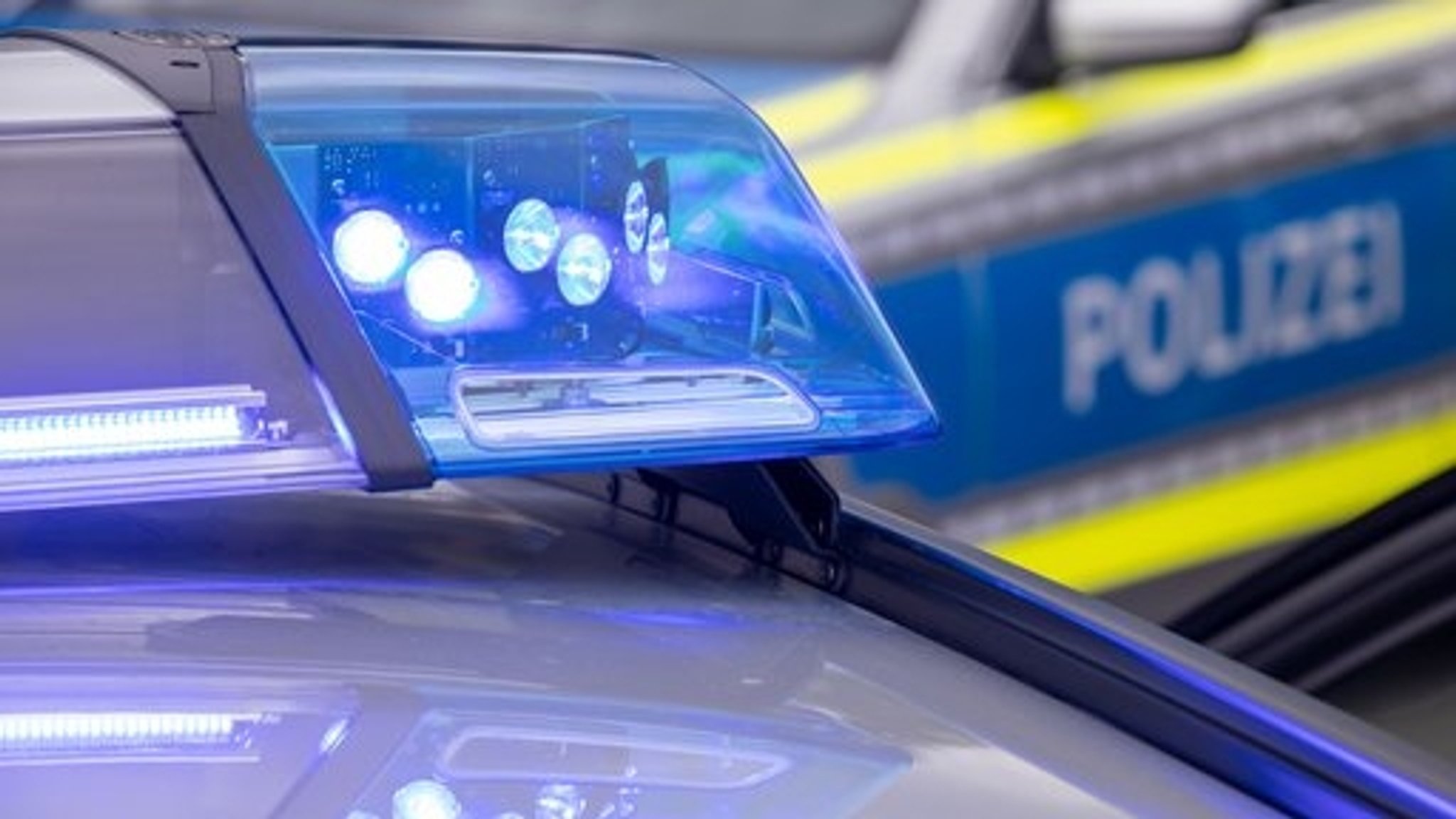 Ein Blaulicht auf einem Polizeifahrzeug leuchtet.