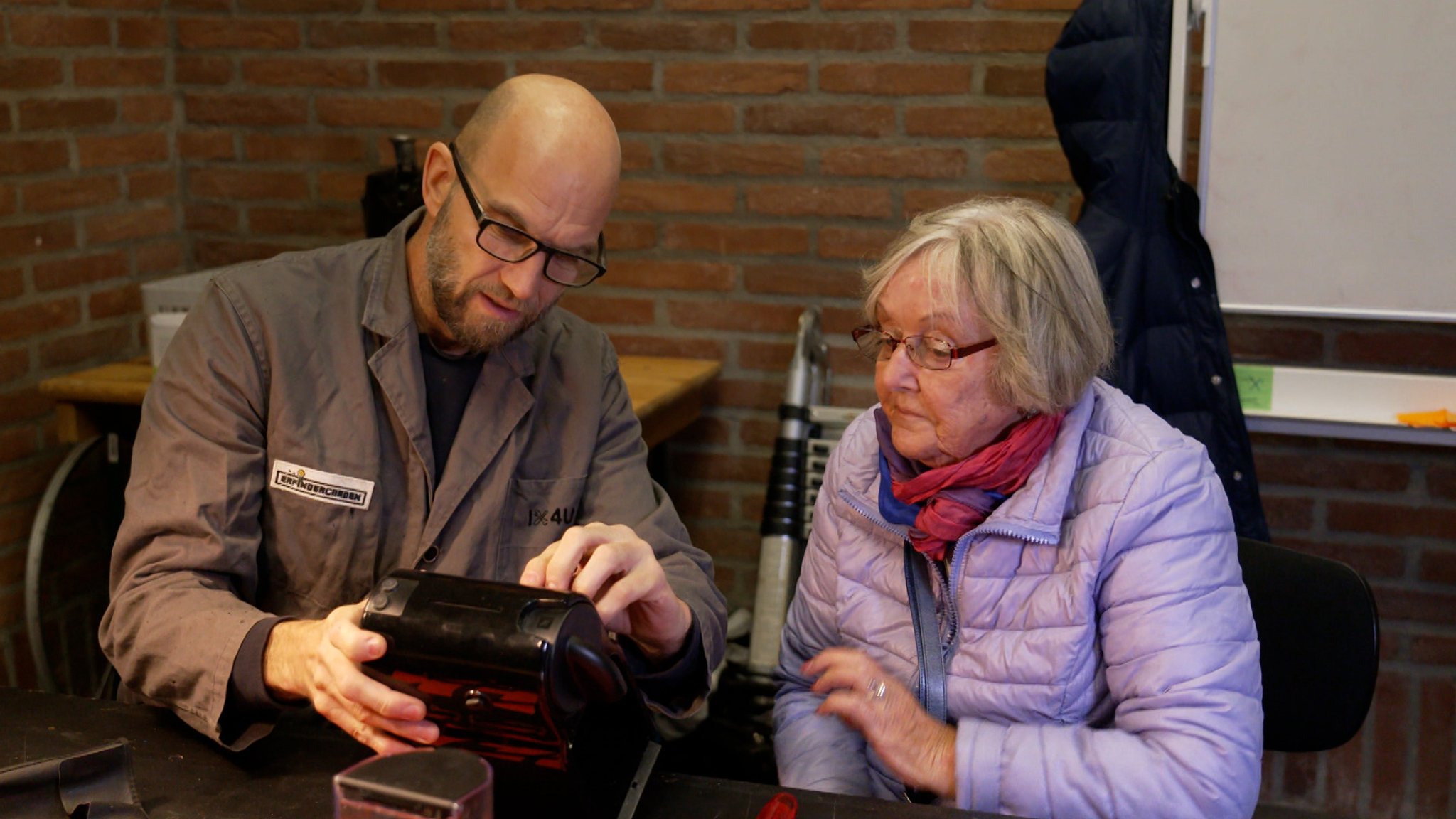 Ein Mann und eine Frau mit einem Elektrogerät.