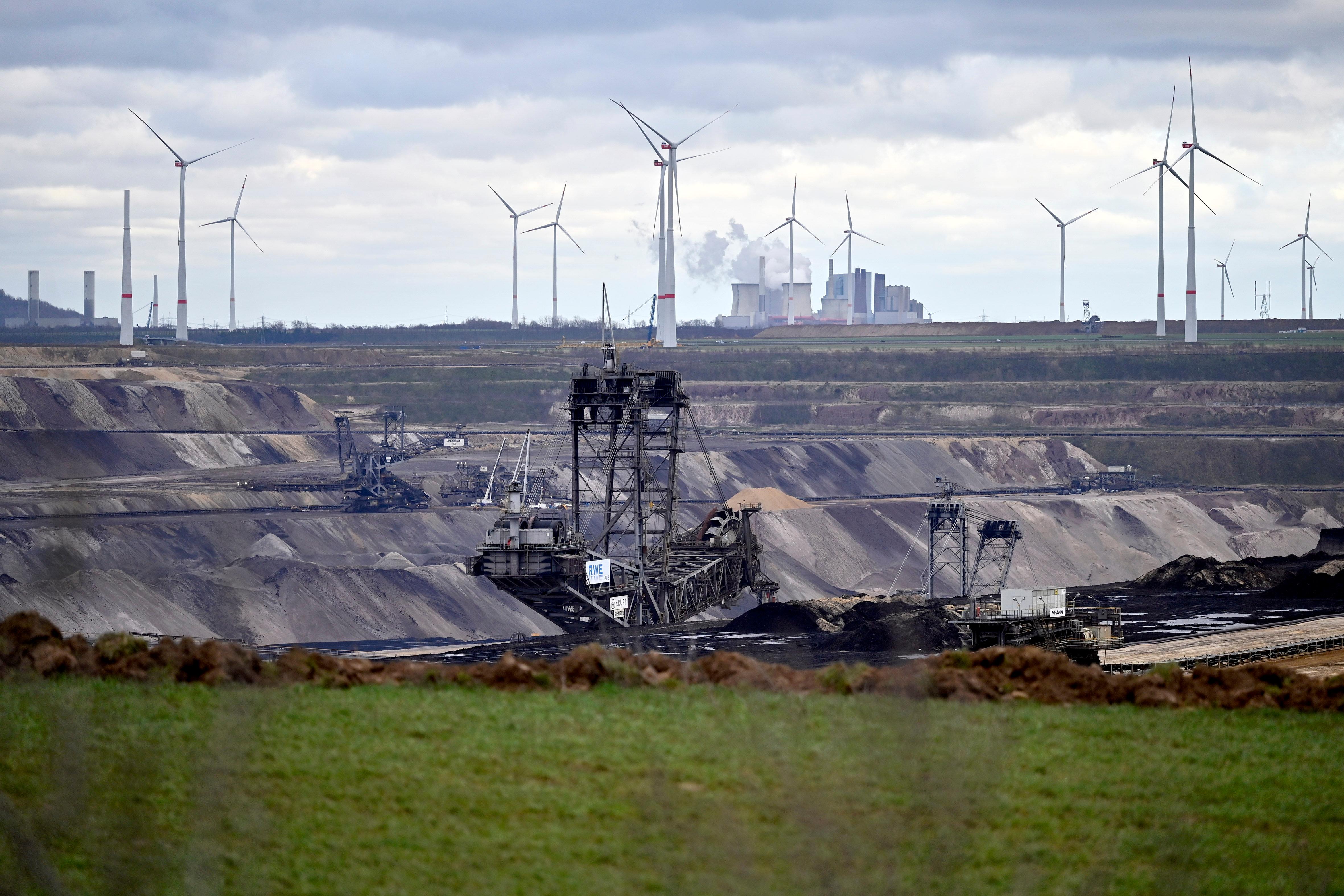 Windkraftanlagen stehen auf einem Feld bei Erkelenz nahe des Braunkohletagebau Garzweiler II, dahinter das Kohlekraftwerk Neurath von RWE. 