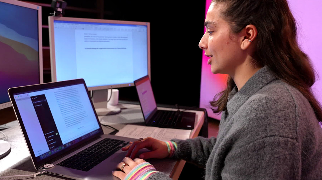 Puls-Reporterin Nadine Hadad sitzt vor einem Laptop. Im Browser ist die Eingabemaske von ChatGPT geöffnet. Man sieht einen längeren Text, den das Programm erzeugt hat. 