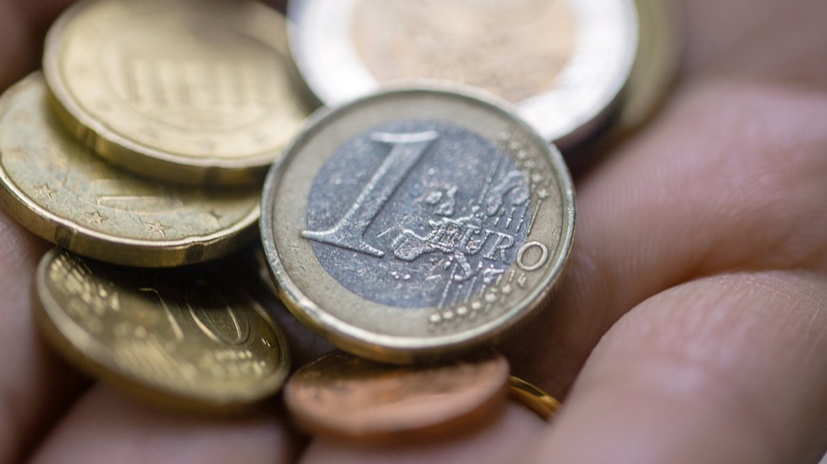 Eine Person hält in einer Hand Euro-Münzen.