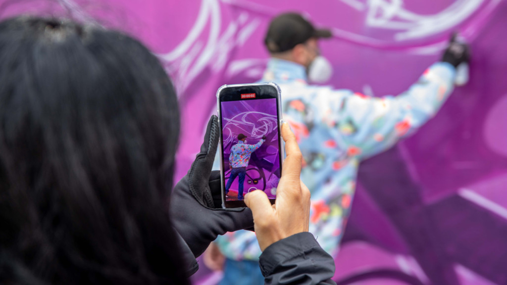 Passantin nimmt Video von Graffiti-Künstler auf