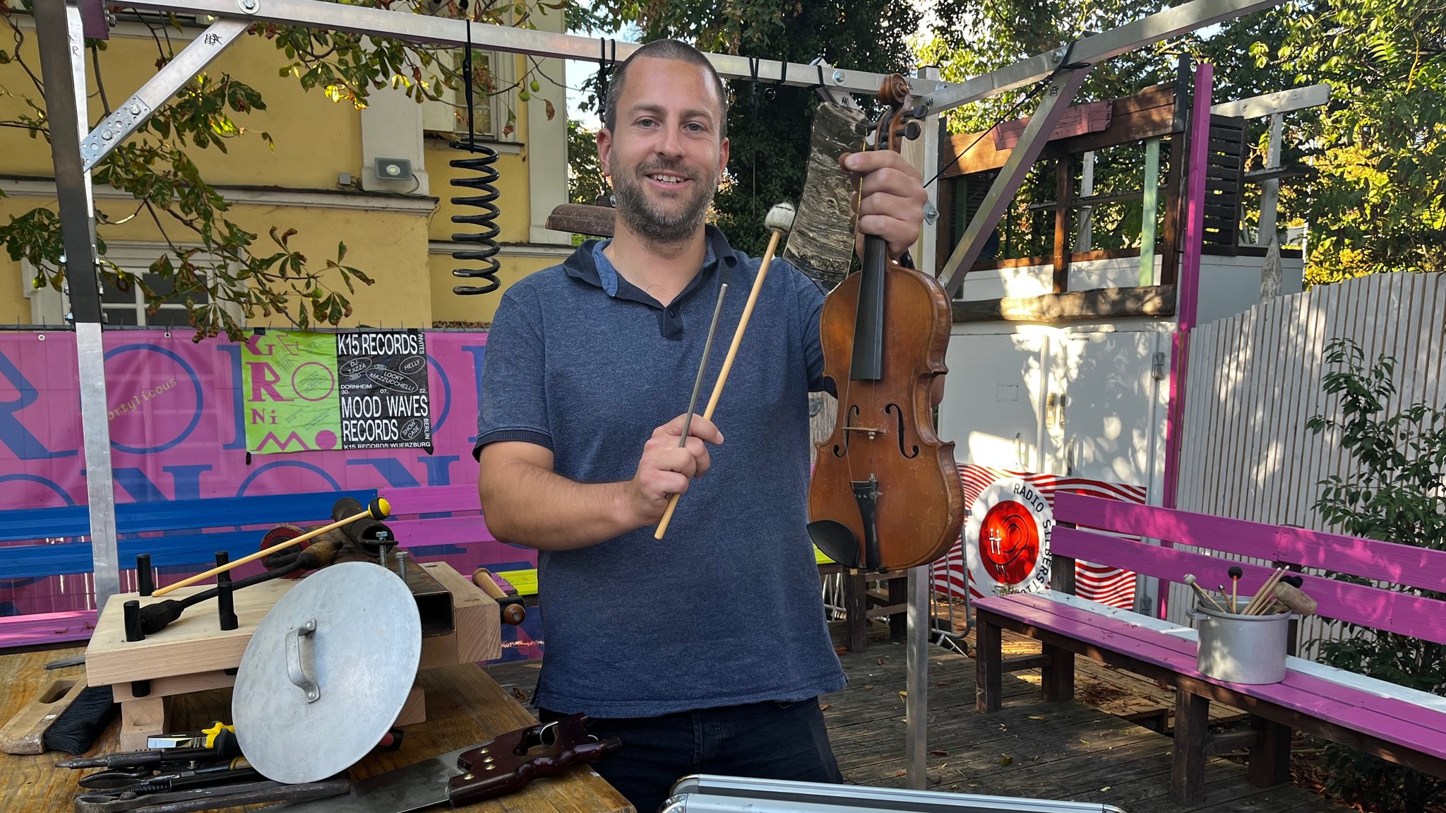 "Schrottmusiker" Tobias Schirmer in seiner aktuellen "Musik-Bastelecke" in einem Würzburger Biergarten auf der Talavera.