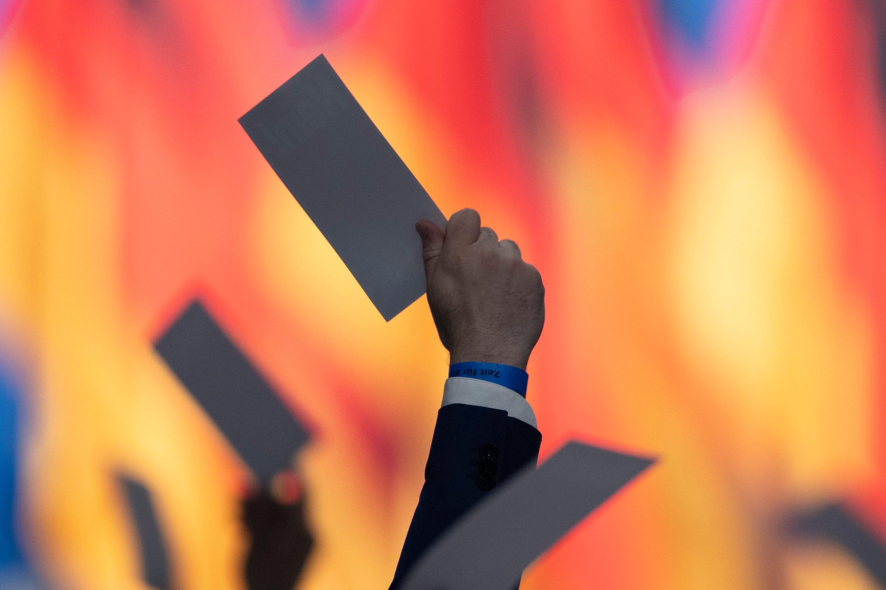 Die Abgeordneten halten auf dem Bundesparteitag der AfD während einer Abstimmung eine Stimmkarte.