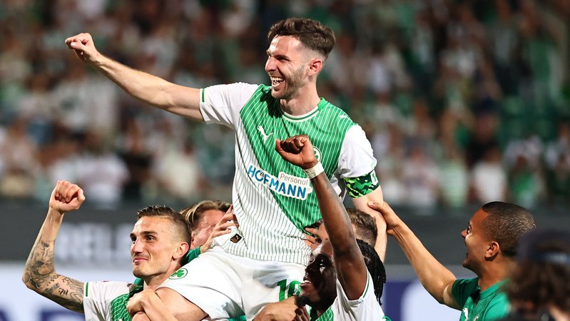 26.05.2026, Bayern, Fürth: Fußball, Männer: 2. Bundesliga - Relegation, SpVgg Greuther Fürth - Rot-Weiss Essen, Philipp Ziereis (SpVgg Greuther Fürth), Branimir Hrgota (SpVgg Greuther Fürth) und Noel Futkeu (SpVgg Greuther Fürth) (l-r) feiern nach der Partie. Foto: Daniel Karmann/dpa - WICHTIGER HINWEIS: Gemäß den Vorgaben der DFL Deutsche Fußball Liga bzw. des DFB Deutscher Fußball-Bund ist es untersagt, in dem Stadion und/oder vom Spiel angefertigte Fotoaufnahmen in Form von Sequenzbildern und/oder videoähnlichen Fotostrecken zu verwerten bzw. verwerten zu lassen. +++ dpa-Bildfunk +++ | Bild: dpa-Bildfunk/Daniel Karmann 26.05.2026, Bayern, Fürth: Fußball, Männer: 2. Bundesliga - Relegation, SpVgg Greuther Fürth - Rot-Weiss Essen, Philipp Ziereis (SpVgg Greuther Fürth), Branimir Hrgota (SpVgg Greuther Fürth) und Noel Futkeu (SpVgg Greuther Fürth) (l-r) feiern nach der Partie. Foto: Daniel Karmann/dpa - WICHTIGER HINWEIS: Gemäß den Vorgaben der DFL Deutsche Fußball Liga bzw. des DFB Deutscher Fußball-Bund ist es untersagt, in dem Stadion und/oder vom Spiel angefertigte Fotoaufnahmen in Form von Sequenzbildern und/oder videoähnlichen Fotostrecken zu verwerten bzw. verwerten zu lassen. +++ dpa-Bildfunk +++