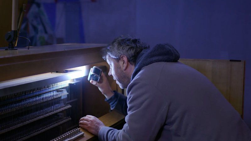 Inspektion der Orgel mit einer Taschenlampe.