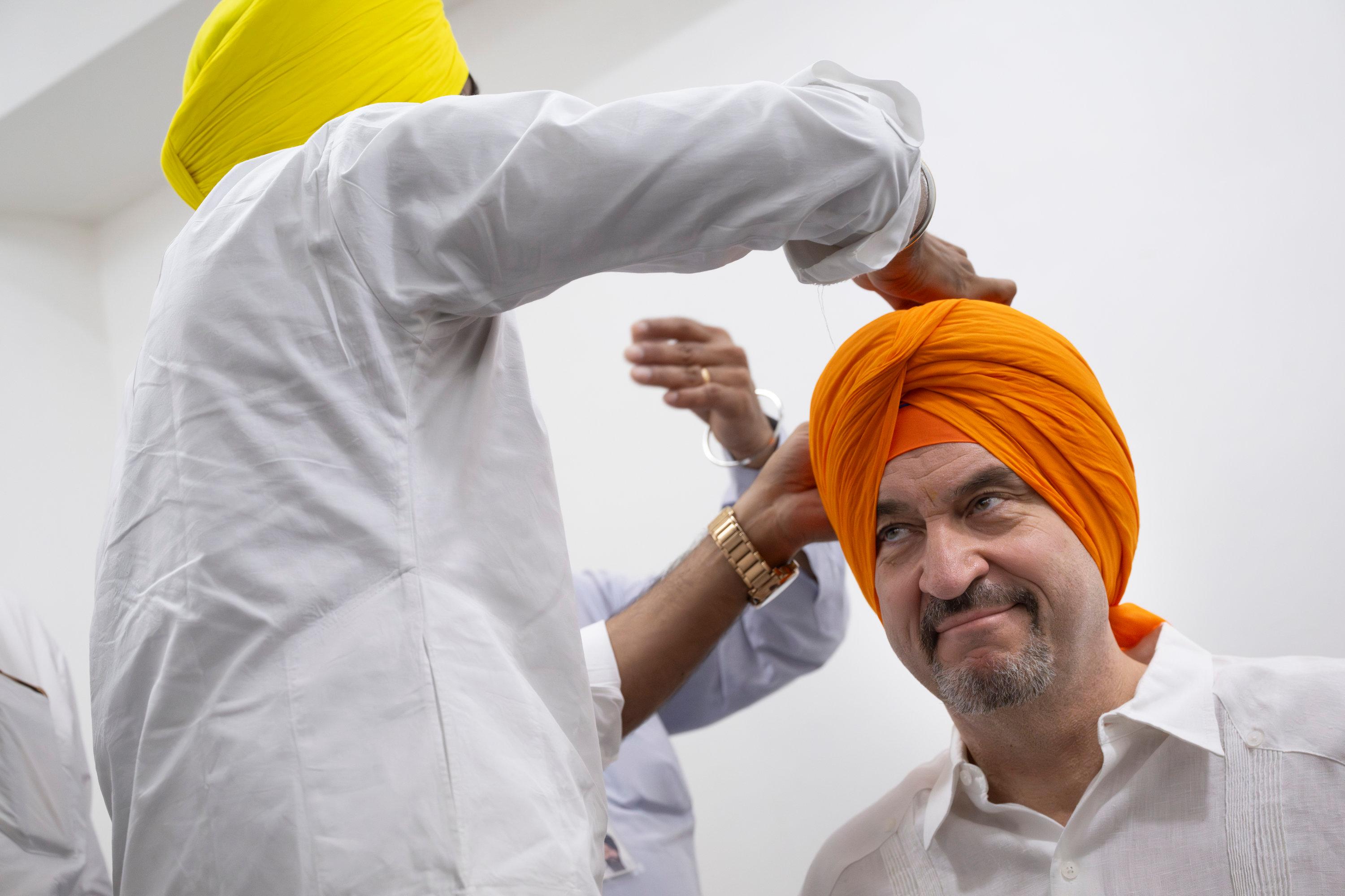Markus Söder (CSU), Ministerpräsident von Bayern, bekommt zu Beginn seines Besuchs des Sikh-Tempels "Gurudwara Bangla Sahib" einen orangenen Turban. Söder befindet sich auf einer mehrtägigen Indienreise.